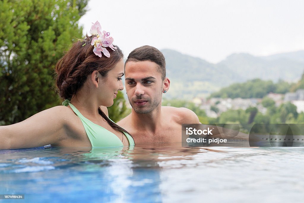若い女性および男性リゾートのプールでリラックス。 - 1人のロイヤリティフリーストックフォト