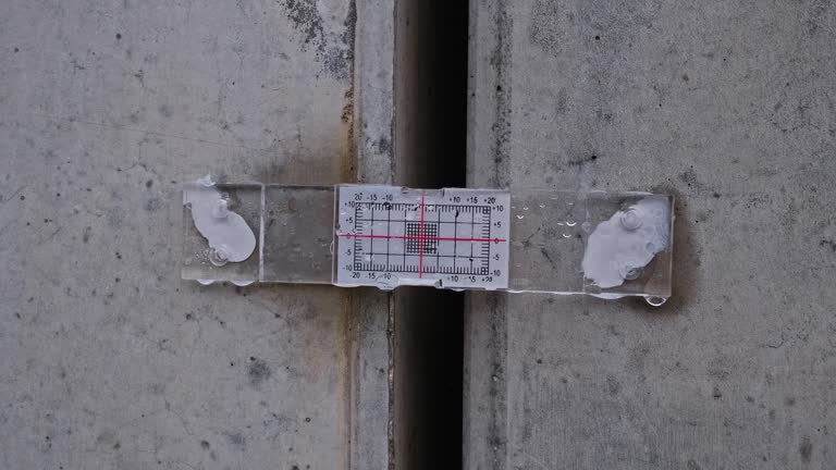 Structural Crack Monitoring Device With Standard Tell Tale Gauge and Scale for Measuring Displacement Fixed to Two Concrete Wall Slabs