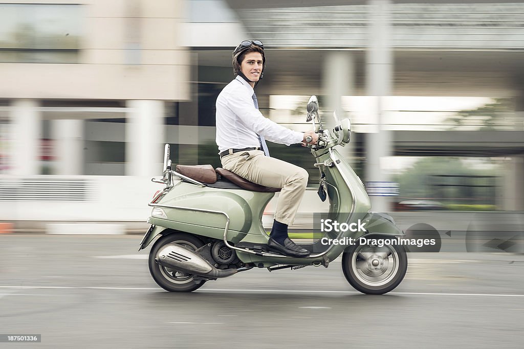 Businessman on wheels Image of a young businessman going at work on the scooter City Stock Photo