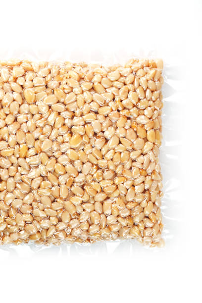 istock Kernels of peeled pine nuts in vacuum packaging on a white background 1875021147