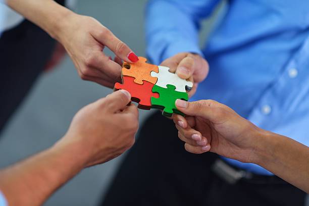 istock Group of business people assembling jigsaw puzzle 187502197