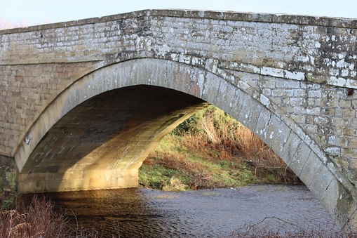 Stone arch bridge crossing a countryside river