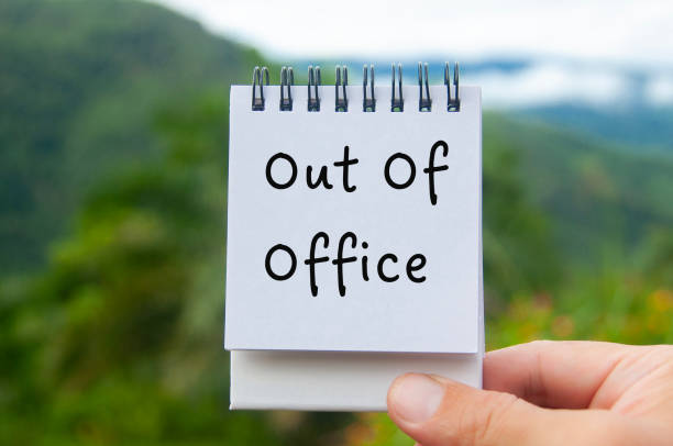 istock Hand holding notepad with Out Of Office text with nature background. 1875042892