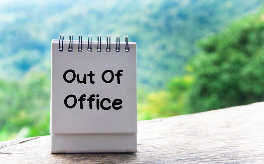 Out Of Office text on notepad with nature background.