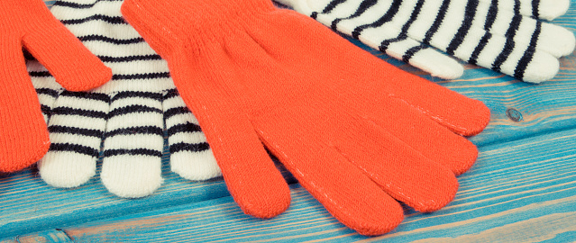 Red and striped womanly gloves for autumn or winter, warm clothing concept