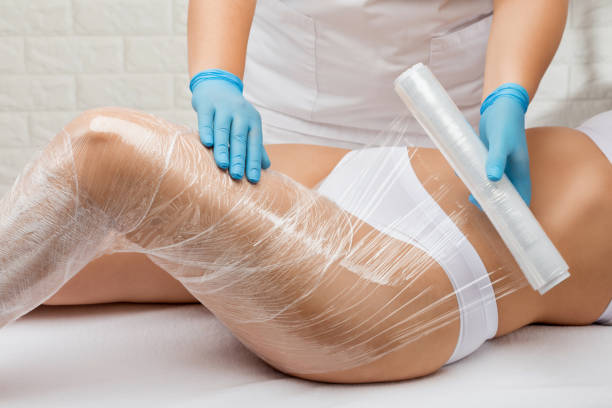 the masseur does a full body wrap cosmetic procedure in a beauty salon. spa treatment in a beauty salon - torso physical therapy patient relaxation exercise 뉴스 사진 이미지