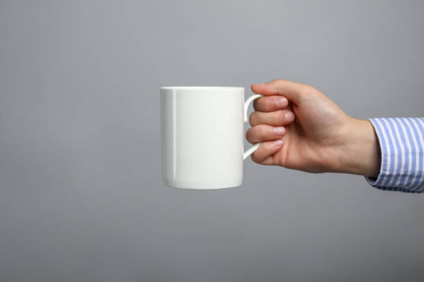 istock Woman holding white mug on light grey background, closeup. Space for text 1875088446