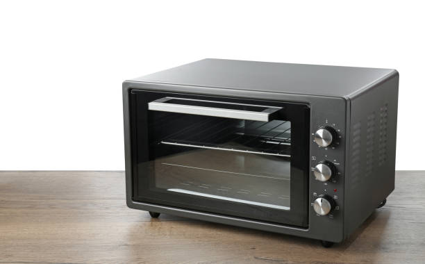 istock One electric oven on wooden table against white background 1875089277