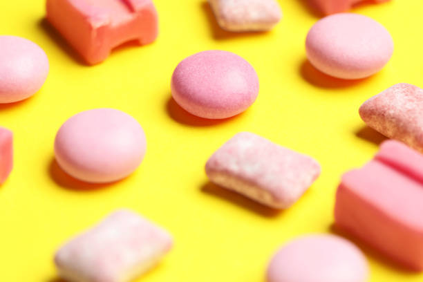 istock Pink bubble gums on yellow background, closeup 1875089811