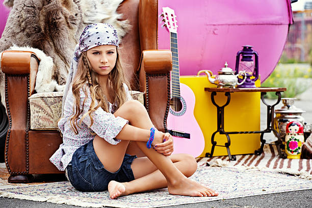 Little girl with blond hair looking at the camera with a sad expression on her face.