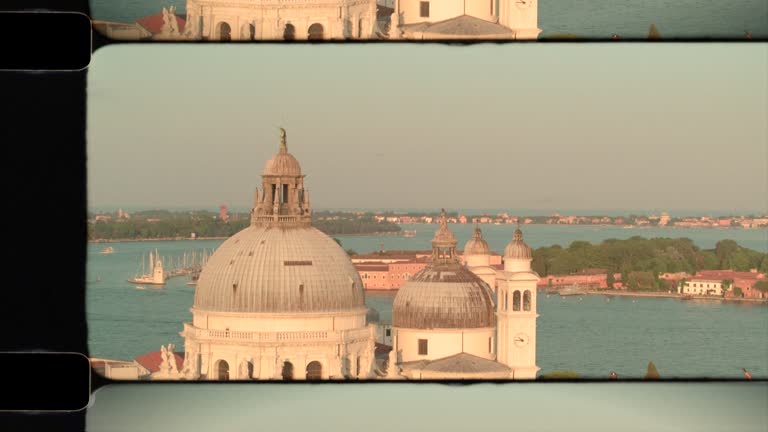 Old Film Aerial View of the dome of the Basilica di Santa Maria della Salute in Venice, Italy in sunshine. 4K