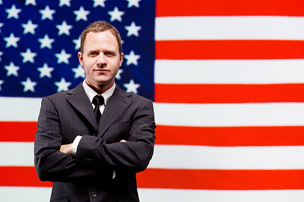 istock Businessman standing in front of American flag 187513092