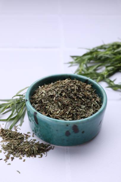 istock Dry and fresh tarragon on white tiled table 1875139249