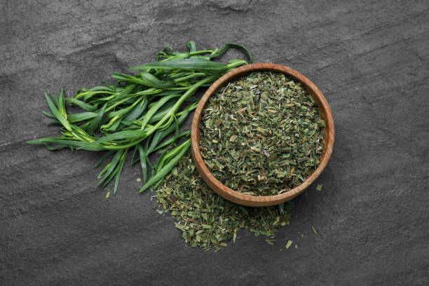 istock Dry and fresh tarragon on black textured table, flat lay 1875144502