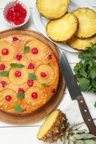 istock Delicious pineapple pie with cherry and mint on white wooden table, flat lay 1875157218