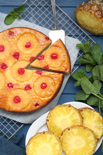 istock Delicious cut pineapple pie with cherry and mint on blue wooden table, flat lay 1875157227