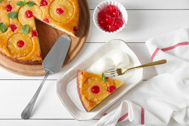 istock Delicious cut pineapple pie served with ice cream on white wooden table, flat lay 1875157342