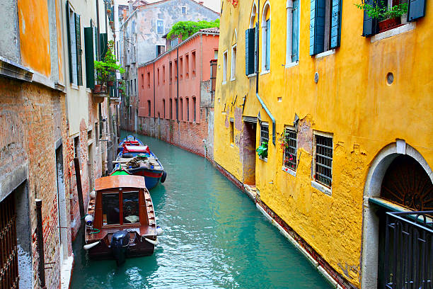 Narrow canal with boats in Venice, Italy