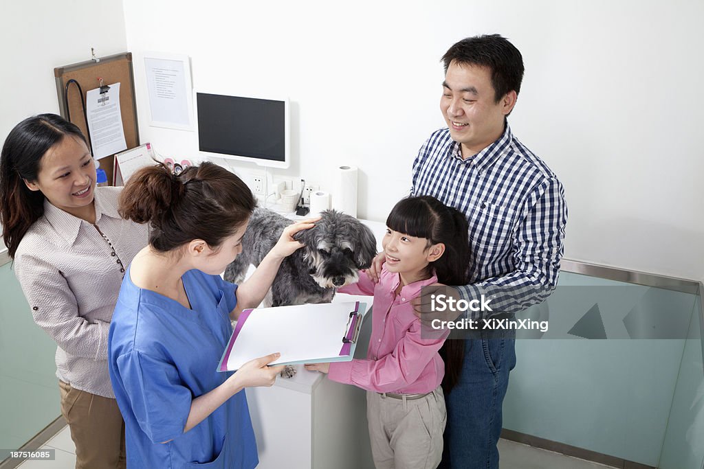 Family with pet dog in veterinarian's office 10-11 Years Stock Photo