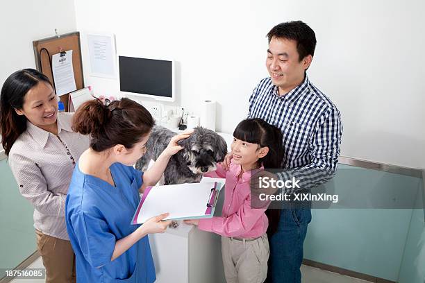 Family With Pet Dog In Veterinarians Office Stock Photo - Download Image Now - 10-11 Years, 30-34 Years, Adult