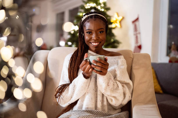 istock Woman Black ethnicity enjoying Christmas atmosphere, while drinking hot chocolate 1875173532