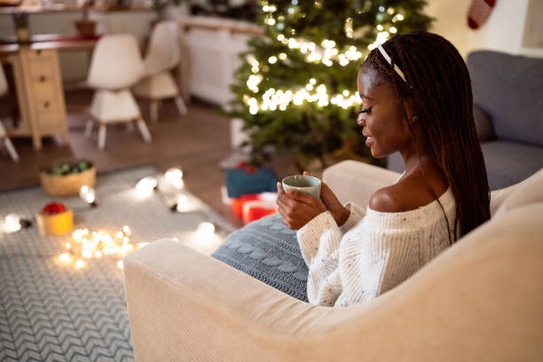 istock Woman Black ethnicity enjoying Christmas atmosphere, while drinking hot chocolate 1875173536