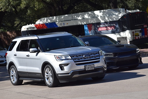 Houston, TX USA 12-19-2023 - A portrait of a Ford Expedition SUV and Dodge Charger cruising side by side near Herman Park in Houston