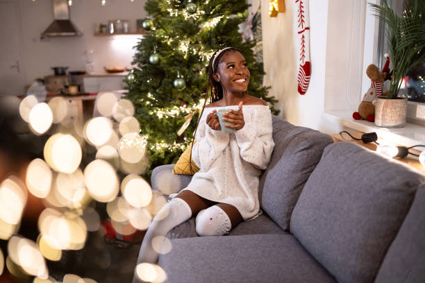istock Woman Black ethnicity enjoying Christmas atmosphere, while drinking hot chocolate 1875180006
