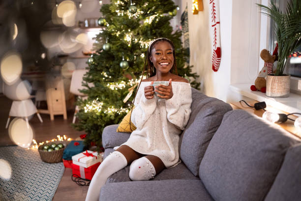 istock Woman Black ethnicity enjoying Christmas atmosphere, while drinking hot chocolate 1875180008