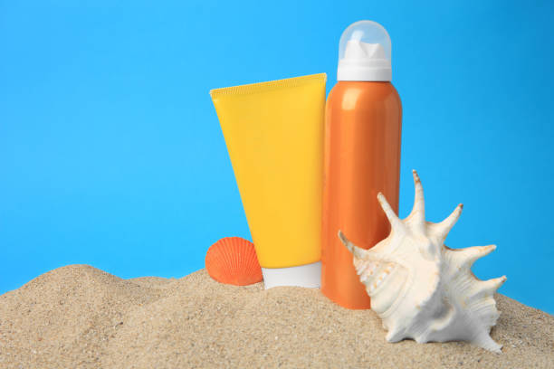 istock Sand with sunscreens and seashells against blue background, space for text. Sun protection care 1875192997