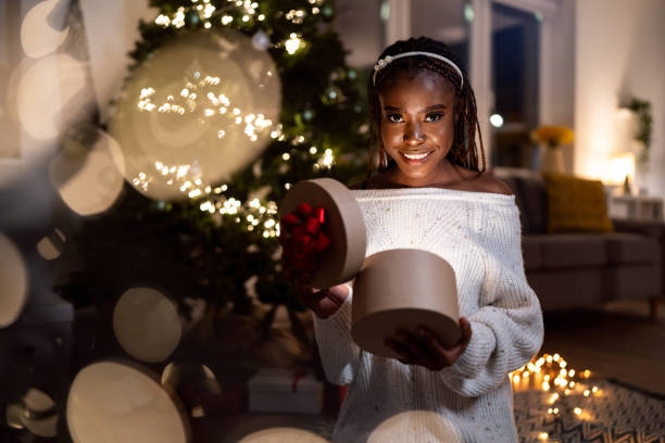 istock Woman Black ethnicity opening the Christmas present 1875200364