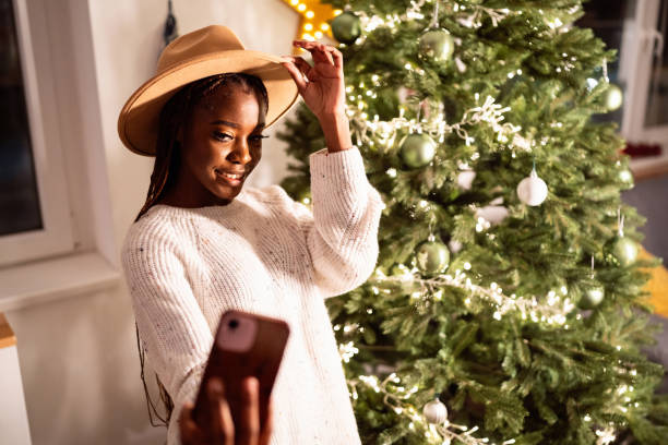 Woman Black ethnicity taking selfie in front of the Christmas tree