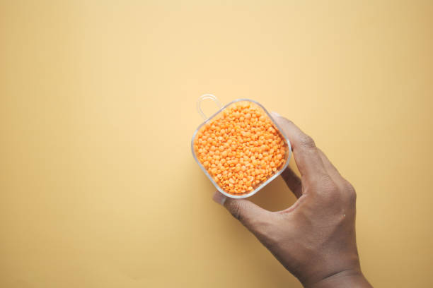 istock Bowl of uncooked dhal on light orange background 1875211935