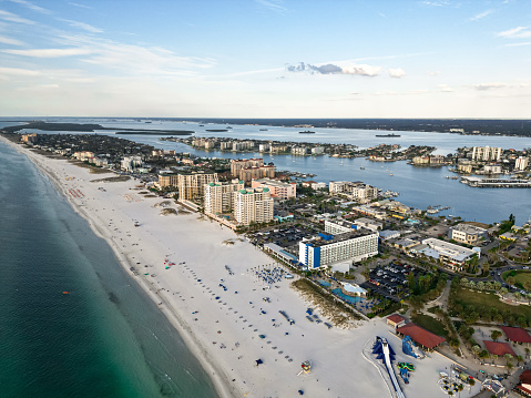 Transport yourself to the tranquil shores of Florida with this captivating drone photo. The sun sets over the Atlantic Ocean, casting a warm glow on a majestic pier that extends gracefully into the water. The elevated perspective captures the pier's intricate design and the vibrant play of colors on the rippling waves below.\n\nThis image exudes coastal charm and serenity, making it ideal for travel brochures, website banners, or any project in need of a calming aesthetic. The simplicity of the pier against the expansive ocean backdrop provides ample space for text overlay, ensuring its versatility for various creative endeavors.\n\nWhether you're curating content for a coastal campaign or seeking an escape through visual storytelling, this Florida ocean pier photo is a timeless addition to your collection. Purchase the license today and infuse your projects with the allure of sunset serenity on the Sunshine State's shoreline.