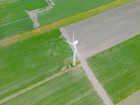 Aerial drone view of wind power turbines, part of a wind farm. Wind turbines on green field in countryside. Wind power plant.