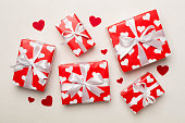 Gift boxes with hearts on concrete background, top view