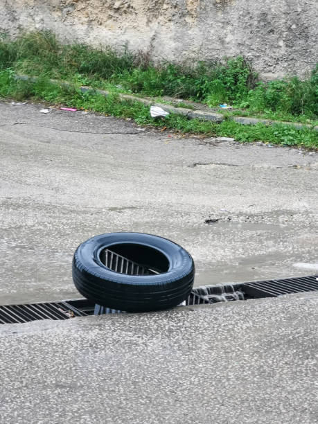 le pneu sert d’avis et de barrière à un drain d’eau défectueux sur la route - steel photography vertical pittsburgh pennsylvania photos et images de collection