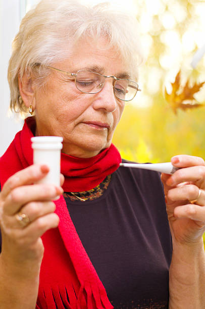 istock Old woman taking her temperature 187526291