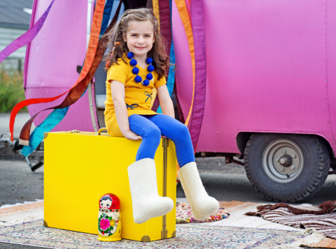 little girl sitting on yellow suit case