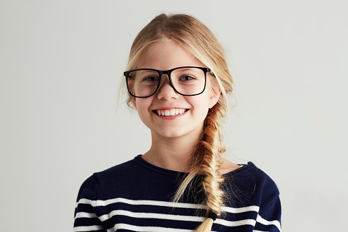 Portrait of a cute girl giving you a toothy smile while wearing hipster glasses