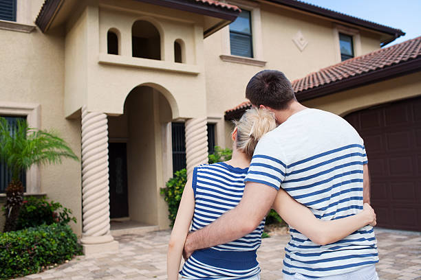 Embracing couple looking at dream house stock photo