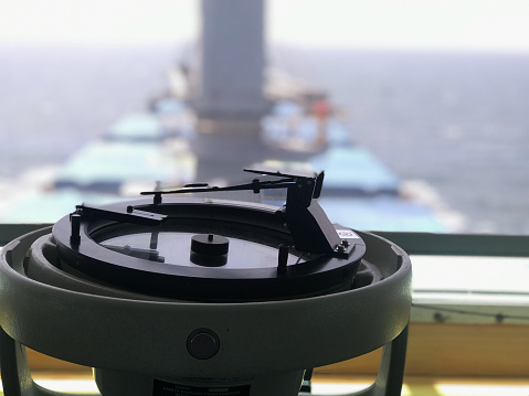 Closeup view of azimuth circle fitted in the bridge of a merchant ship carrying bulk cargo at sea