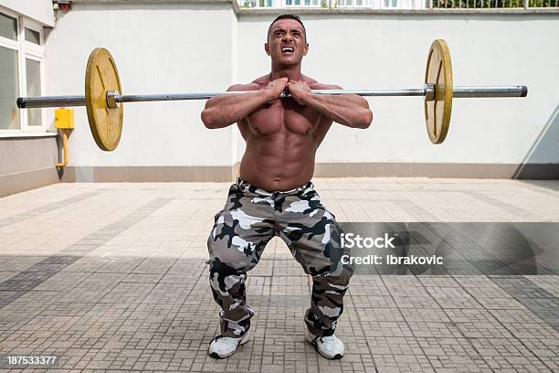 Hombre Haciendo Squats Frontal Foto de stock y más banco de imágenes de Adulto - Adulto, Agacharse, Aire libre