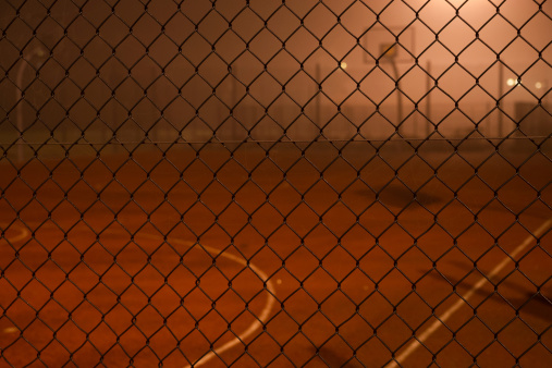 Basketball court in the fog, behind fence