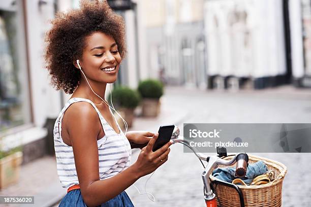 Choosing A Song To Fit Her Mood Stock Photo - Download Image Now - Cycling, Cheerful, Happiness