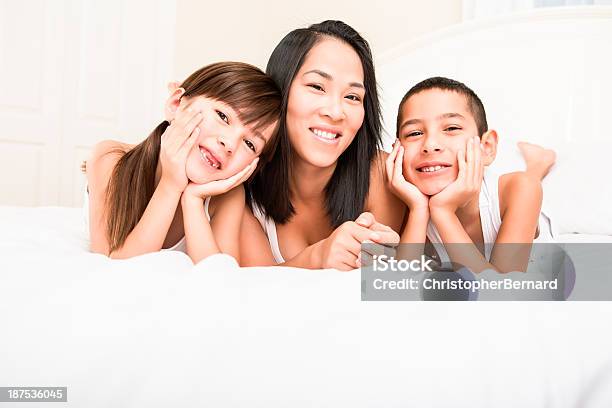Mama I Dzieci Leżąc Na Łóżku - zdjęcia stockowe i więcej obrazów Dziewczyny - Dziewczyny, Grupa wieloetniczna, Osoba rasy mieszanej