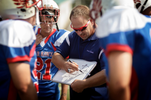 A football coach drawing out a play.