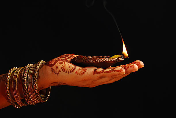 istock Ethnic hand with henna and gold bangles holding candle 187536579