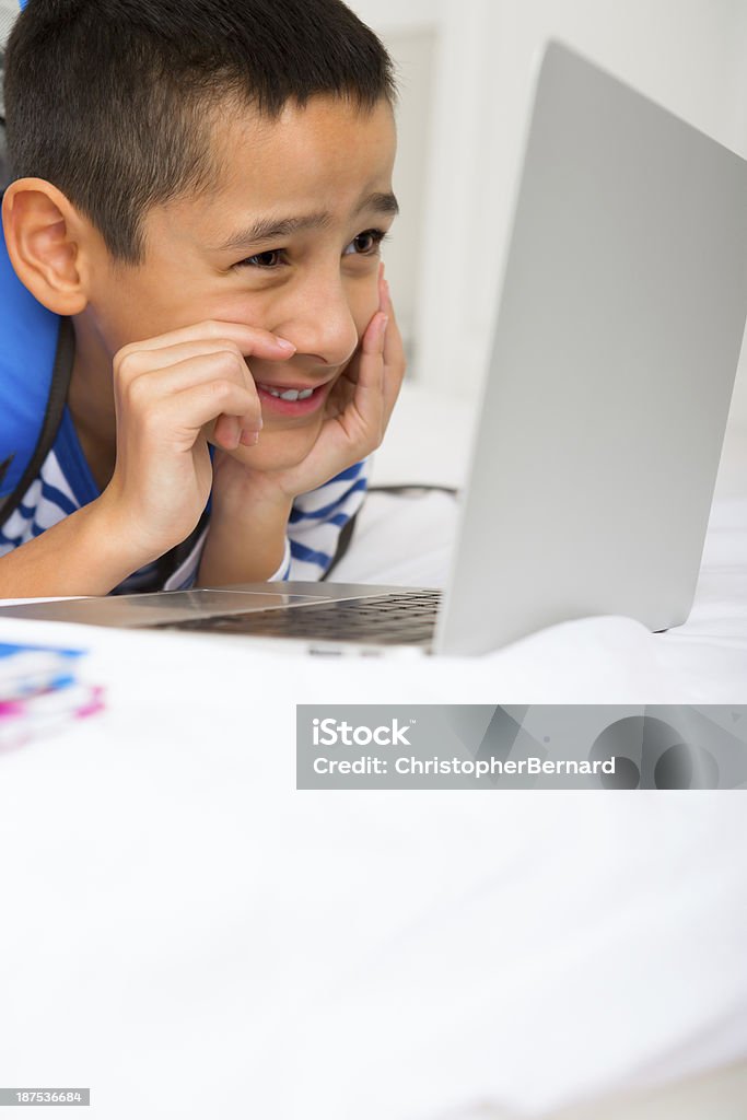 Jeune garçon en train de jouer sur l'ordinateur portable - Photo de 8-9 ans libre de droits