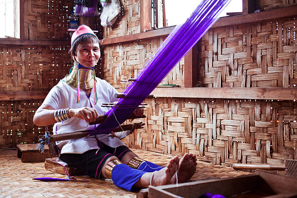 Long necked woman engaged in manual work Long necked woman engaged in manual work padaung tribe stock pictures, royalty-free photos & images
